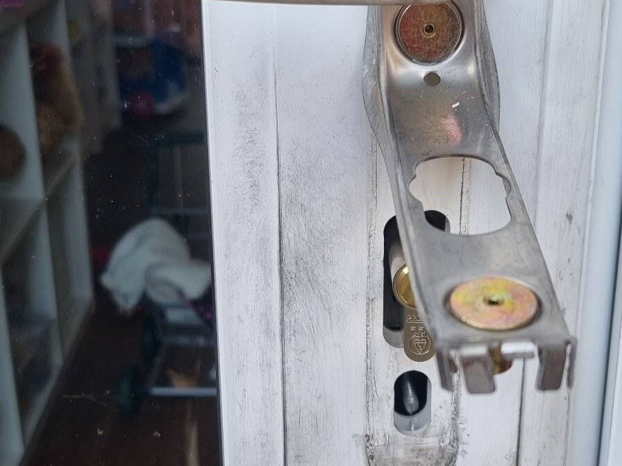 Burglary repair showing damaged door handles after forced entry via lock snapping 